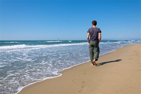 Man walking on the beach stock photo. Image of outdoor - 69631048