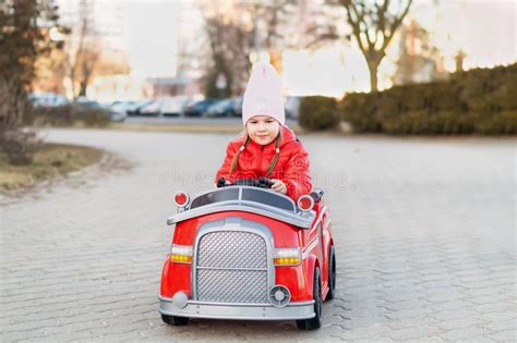 Funny Cute Girl Driving a Big Toy Red Fire Truck. a Little Girl Drives ...