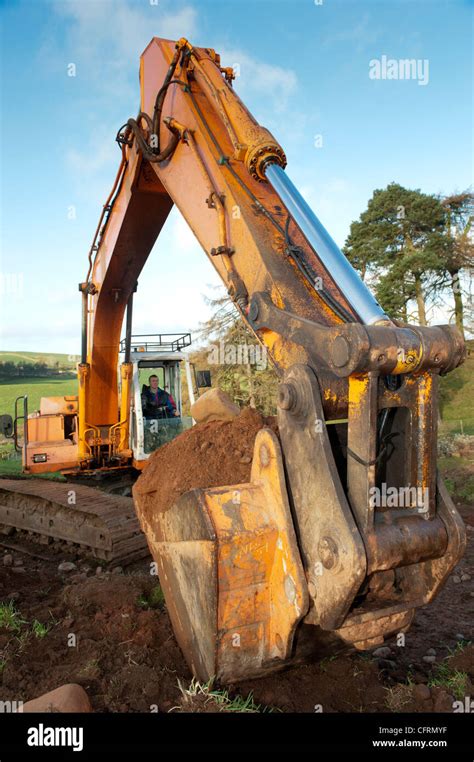 Big excavator digging stone on a hillside Stock Photo - Alamy