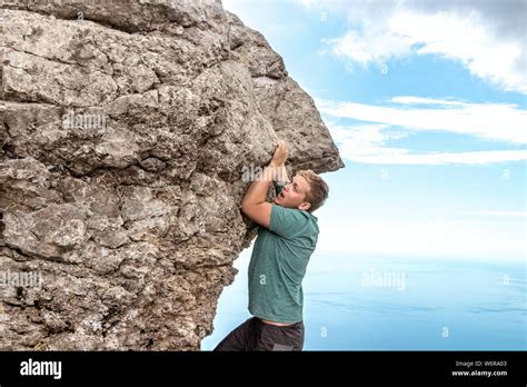 Adult male hanging cliff hi-res stock photography and images - Alamy