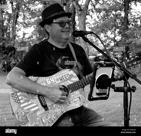 Man singing with guitar at local farmer's market Stock Photo - Alamy