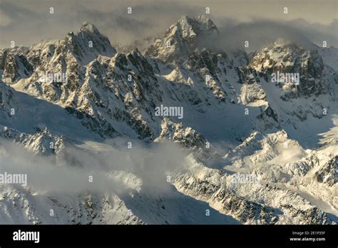 Aerial view of jagged peaks in the Alaska Range with clouds and snow ...