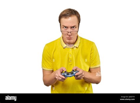 Geek gamer nerd in glasses and yellow T-shirt with gamepad isolated on white background. Young ...