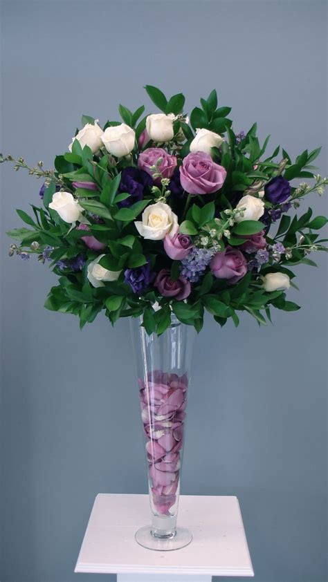 a vase filled with lots of purple and white flowers