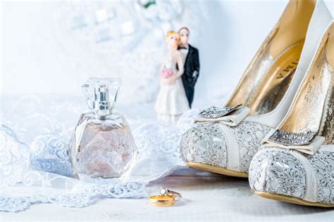Wedding rings, perfume, shoes and statues of the bride and groom on white background - Creative ...