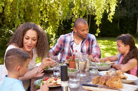 Family At Home Eating Outdoor Meal In Garden Together Stock Photo - Download Image Now - iStock