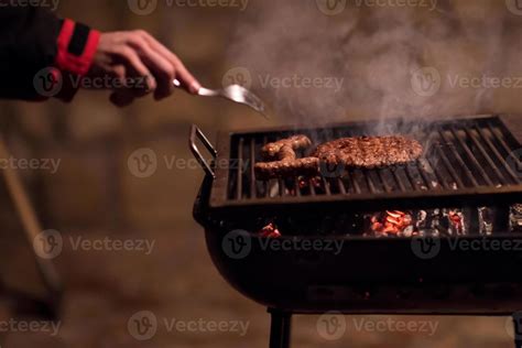 young man cooking meat on barbecue 10119673 Stock Photo at Vecteezy