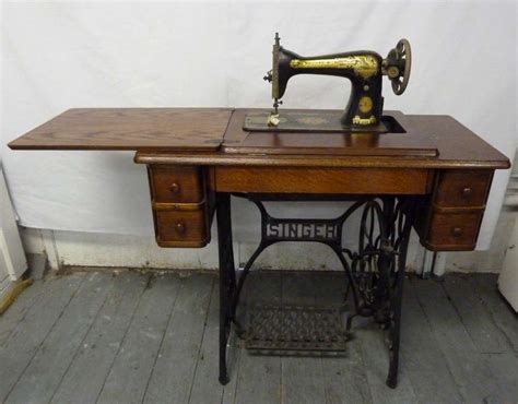 Antique Singer foot pedal operated sewing machine, fold away table top on a cast iron base