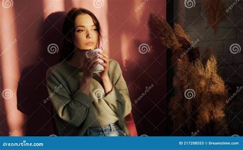 Beautiful Woman Sitting Near Window and Enjoy a Cupt of Tea on Background of Sunset. Stock Video ...