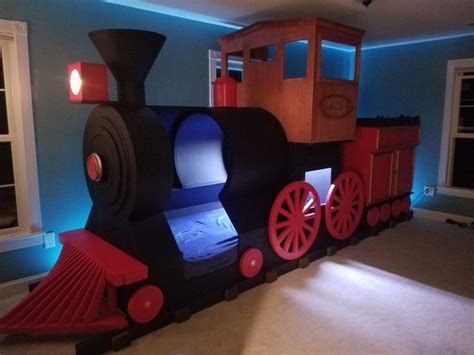 a child's train bed in the shape of a train with lights on it