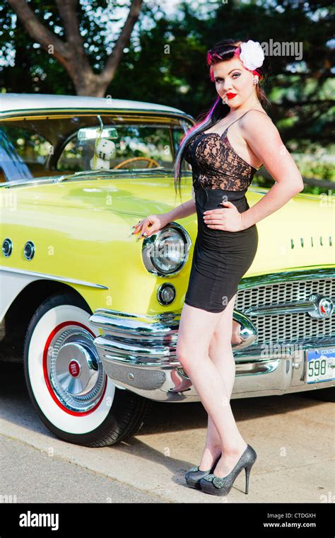 Female woman dressed in a rockabilly fashion posing next to a classic ...