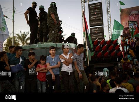 Palestinians gather as Hamas militants parade at a rally just over a ...