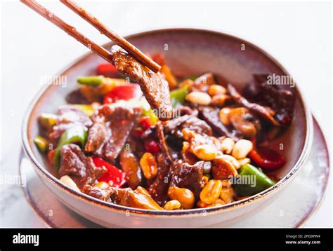 Stir-fried Chinese dish with diced beef, vegetables, and peanuts cooked in a pan Stock Photo - Alamy