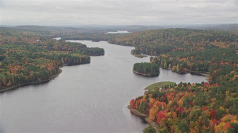 5.5K stock footage aerial video flying by Androscoggin River, colorful forest in autumn ...