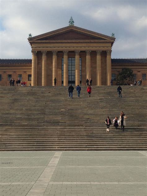 people are sitting on the steps in front of a building