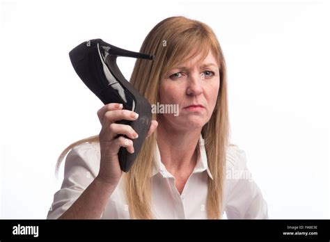 Woman holding a stiletto shoe in extreme anger Stock Photo - Alamy