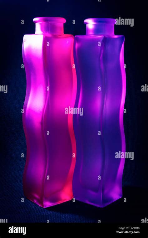 Close-up of two wavy purple and pink frosted glass vases against a dark ...