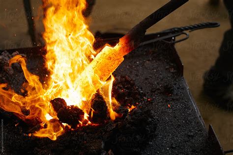 "Close Up Of A Red Hot Iron In The Blacksmith Fire" by Stocksy Contributor "Miquel Llonch" - Stocksy