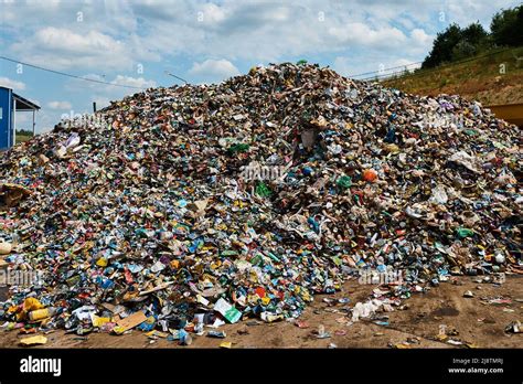 Huge heap of trash at recycling plant under sky with clouds Stock Photo ...