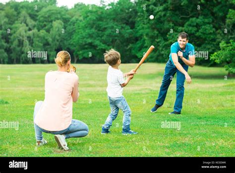 Happy Young Family Playing Baseball At Park Stock Photo - Alamy