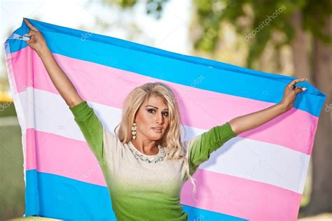 Transgender holding up pride flag Stock Photo by ©lewchin 116549972