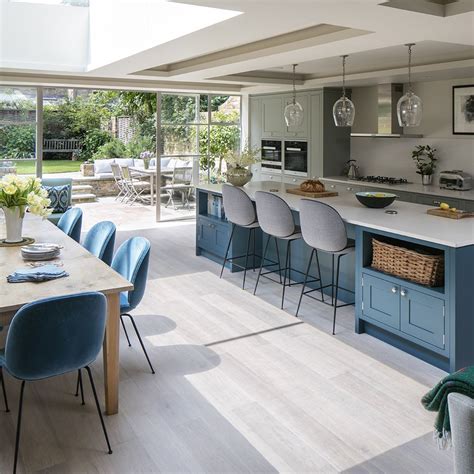 A row of floor-to-ceiling windows and a large skylight work together in this kitchen-diner to ...