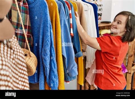 Brunette woman with down syndrome looking at clothes at retail shop Stock Photo - Alamy