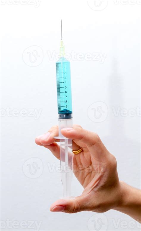 Blue vaccine in syringes on right hand. 993888 Stock Photo at Vecteezy