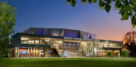 the grand canyon university arena is lit up at night with trees in front of it