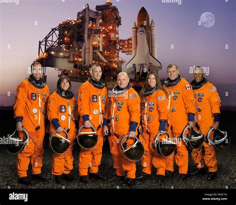 Group portrait of the STS-118 space shuttle crew astronauts in orange launch and entry suits at ...