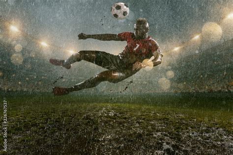 Soccer player on professional soccer night rain stadium. Dirty player ...