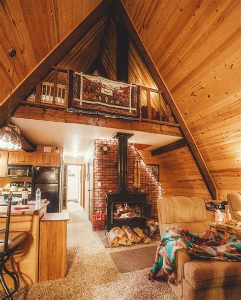 Rustic A-frame interior: A closer view of the entryway, kitchen & wood stove with stair ladder ...