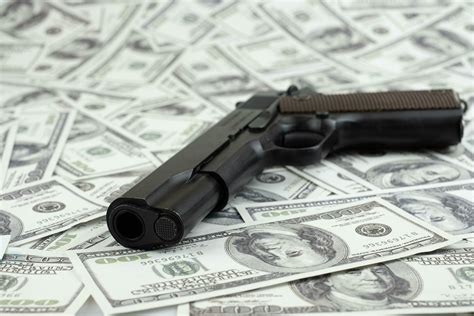 Black gun pistol on stack money 100 dollars background 3710483 Stock ...