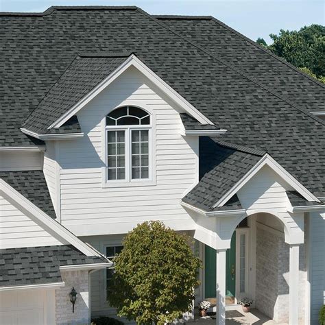 a white house with black shingles and windows