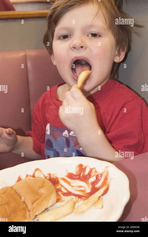 Boy age three eating fast food Stock Photo - Alamy