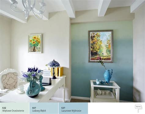 a room with blue and white walls, vases on the table and pictures on the wall