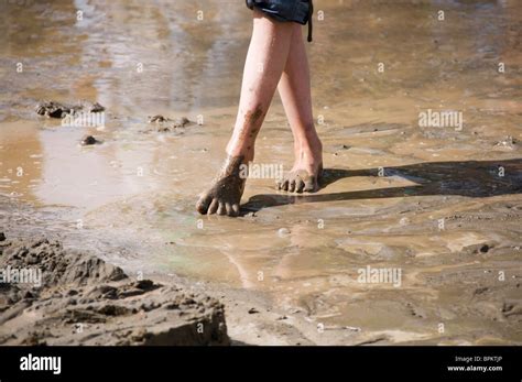 A girl dances barefoot in the mud during the Sand in the City event in ...