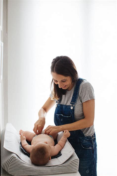 "Portrait Of A Young Mother Giving Baby A Diaper Change." by Stocksy Contributor "BONNINSTUDIO ...