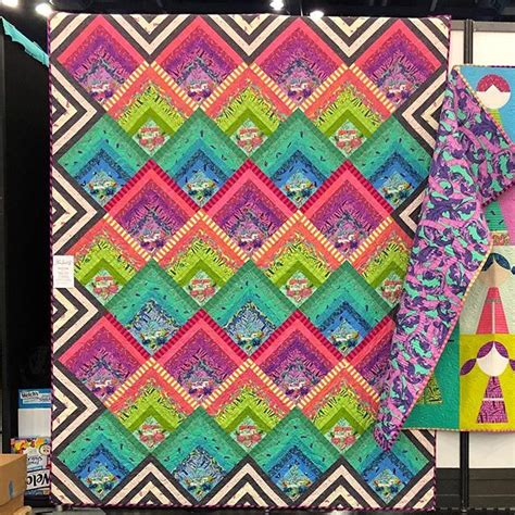 a colorful quilt is hanging on the wall next to other art and craft supplies in a store