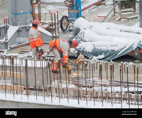 Construction workers and building activity on a snowed winter construction site in Zurich ...