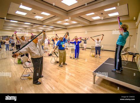 An instructor conducts a chair exercise class for senior women and men ...