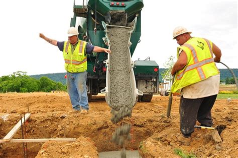 A contractor directs the concrete truck driver during the initial pour ...