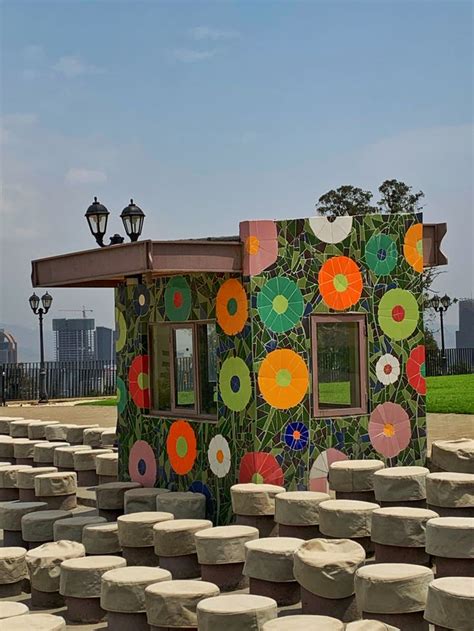 a small building made out of rocks with flowers painted on it