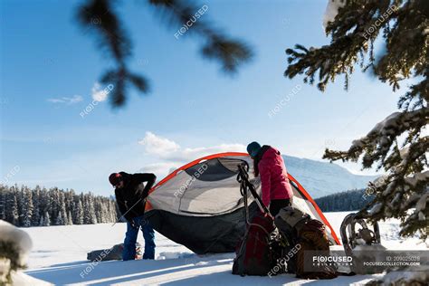 Couple pitching tent in snowy landscape during winter. — nature ...