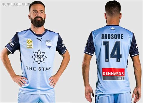 a man with a beard standing next to another man wearing a blue soccer uniform that says broosque ...