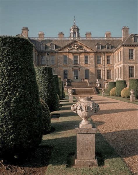 a large building with lots of hedges in front of it