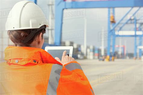 Female dock worker using digital tablet at shipyard - Stock Photo - Dissolve