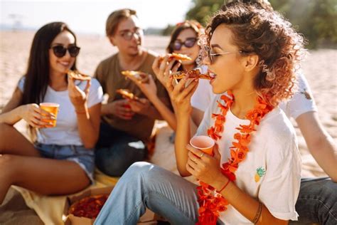 Premium AI Image | Group of young friends having picnic eating pizza ...