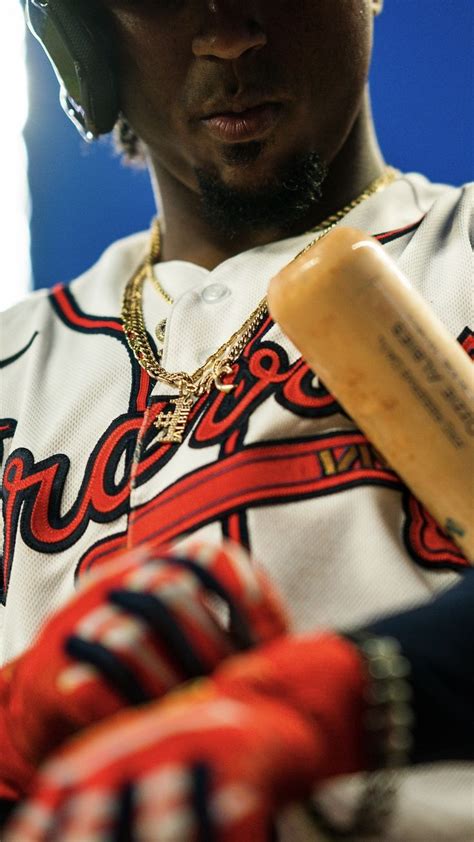 Close-up of Ozzie Albies' chain and jersey as he adjusts his batting ...