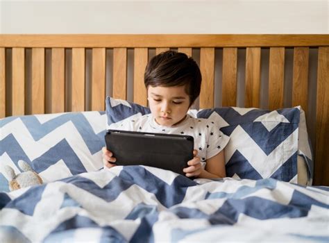 Premium Photo | Kid reading bed time stories on tablet before sleep happy boy sitting in bed ...